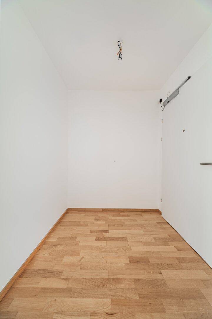 Heller Eingangsbereich mit Holzboden und weißen Wänden.