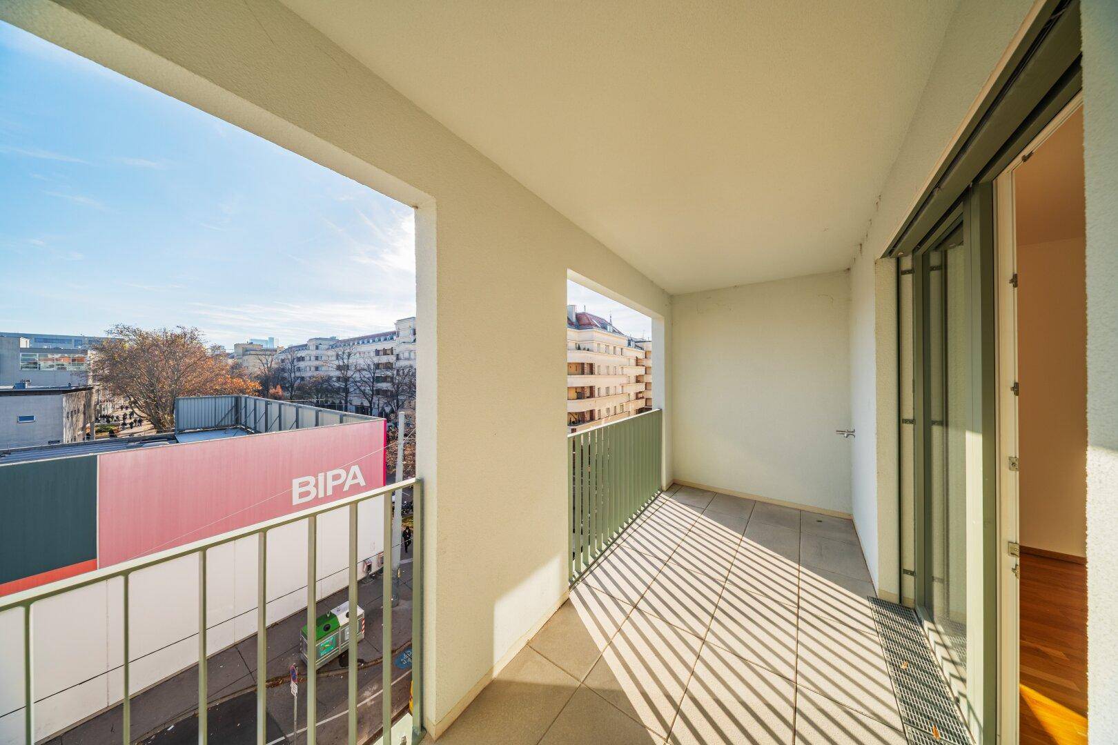 Sonniger Balkon mit Blick auf die Stadt und die umliegende Bebauung.
