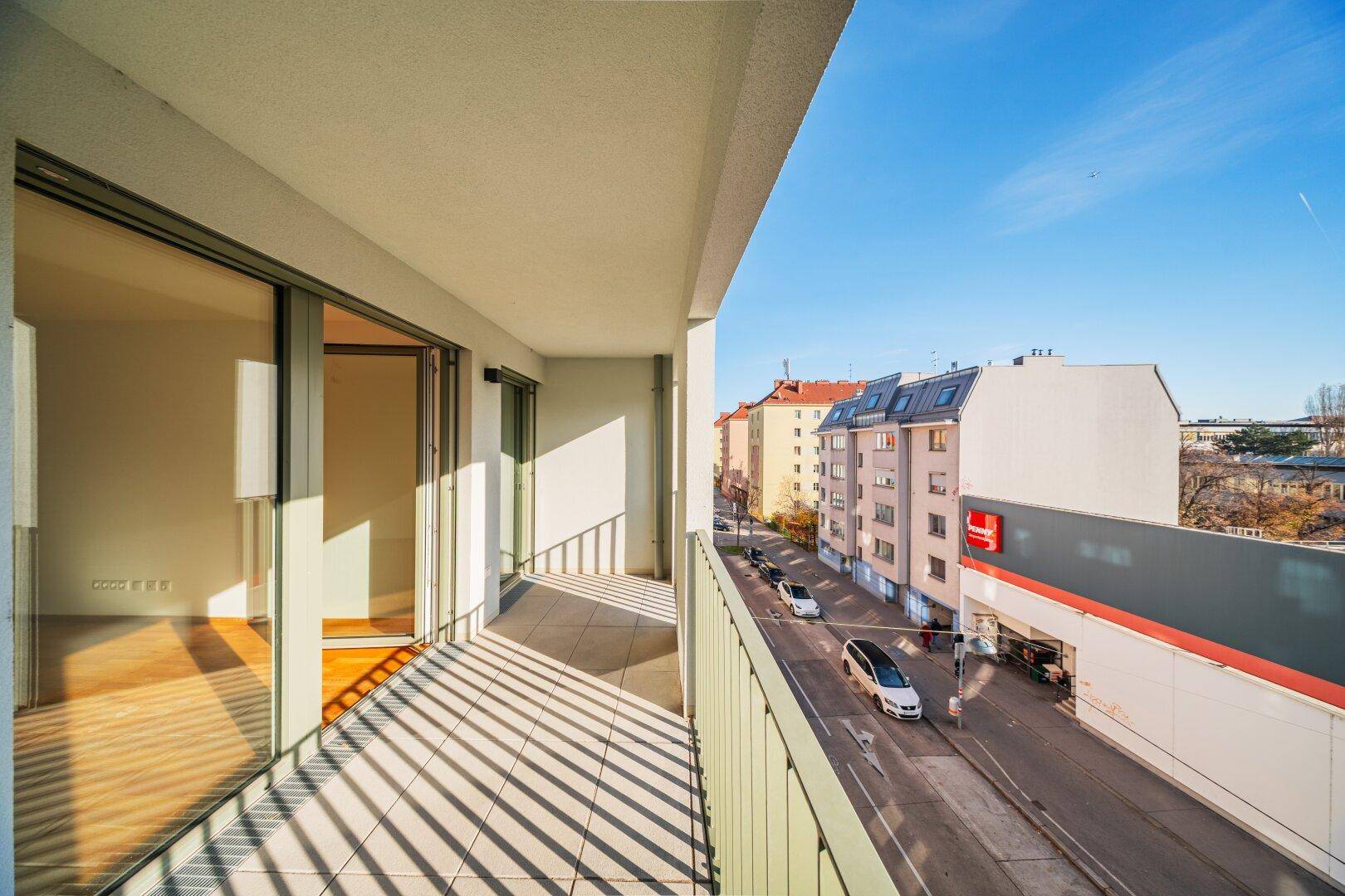 Geräumiger Balkon mit Blick auf die Straße und umliegende Gebäude.