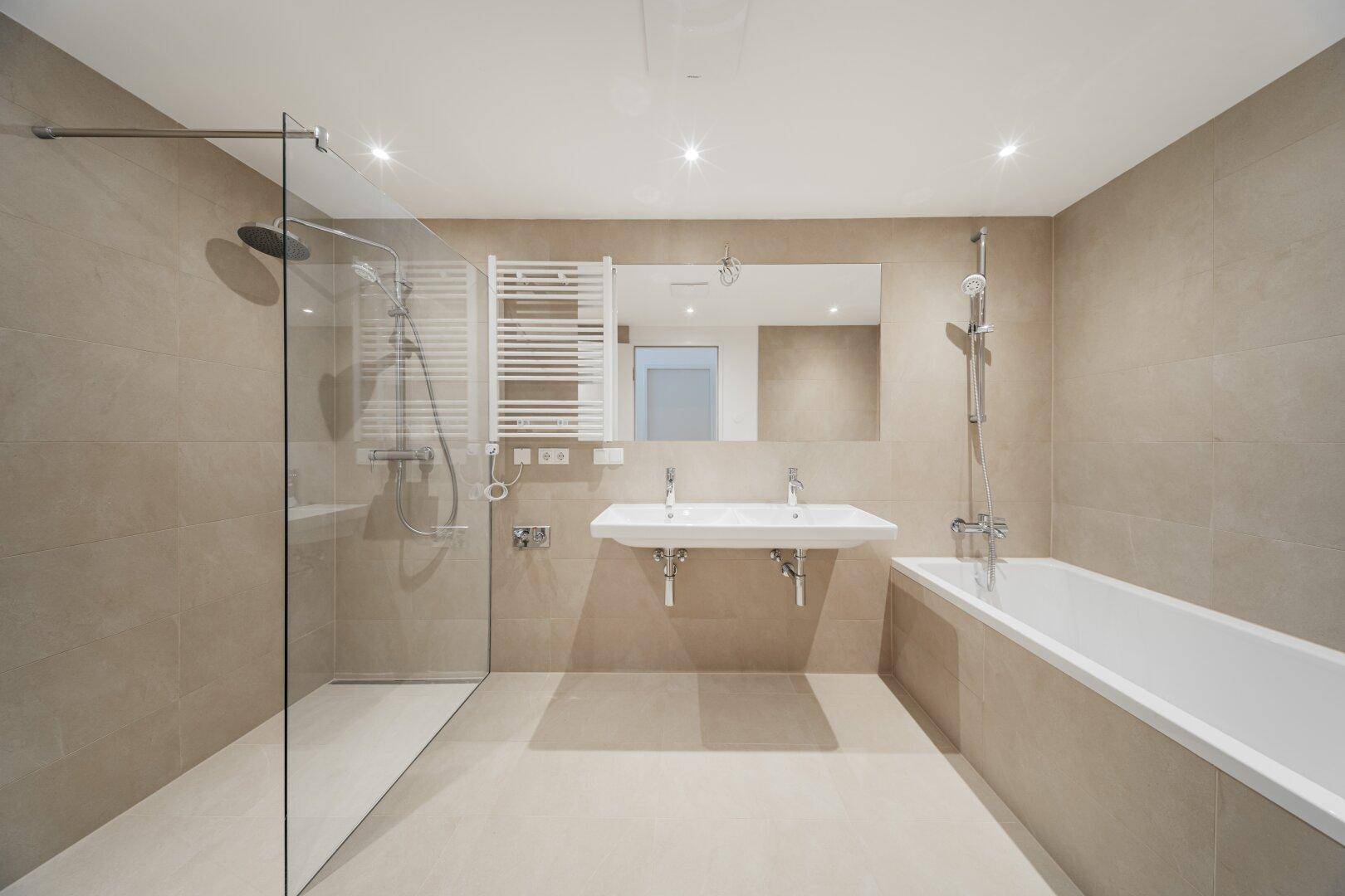 Modernes Badezimmer mit Doppelwaschbecken, Badewanne und großer begehbarer Dusche.
