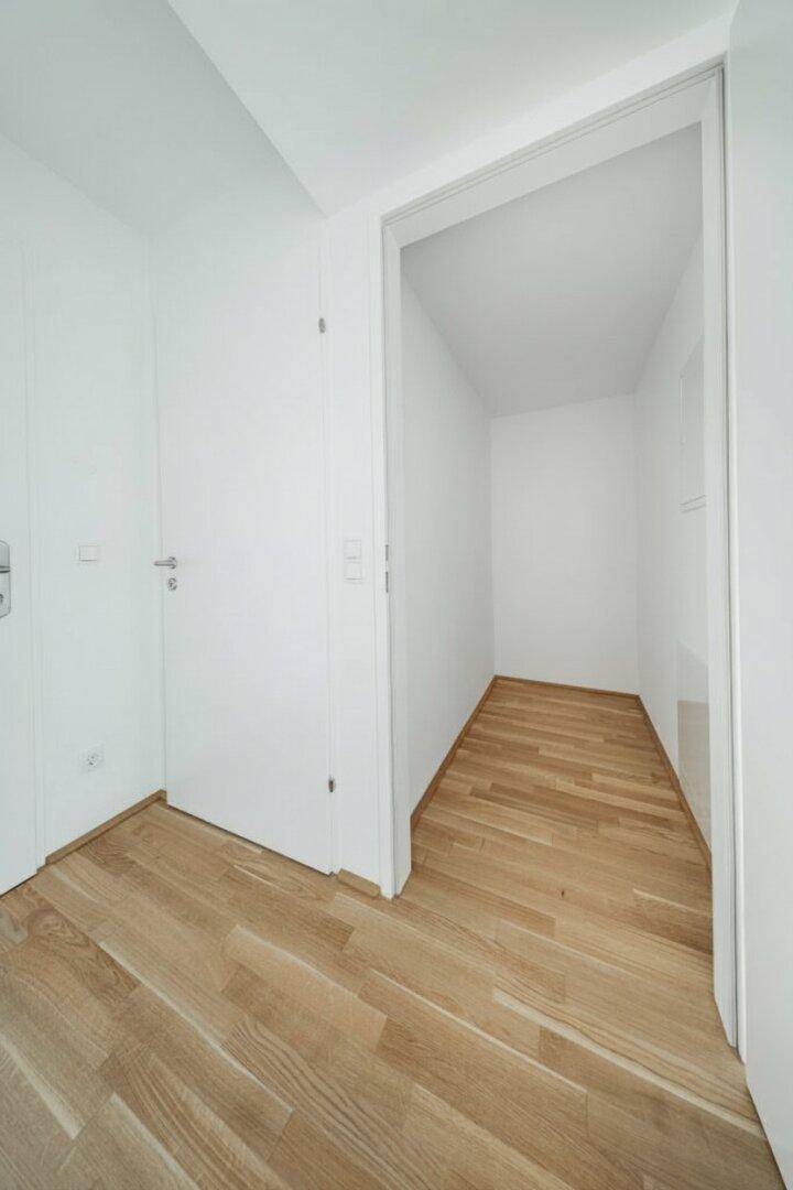 Praktischer Abstellraum mit Holzboden, ideal für zusätzlichen Stauraum oder als begehbarer Kleiderschrank.