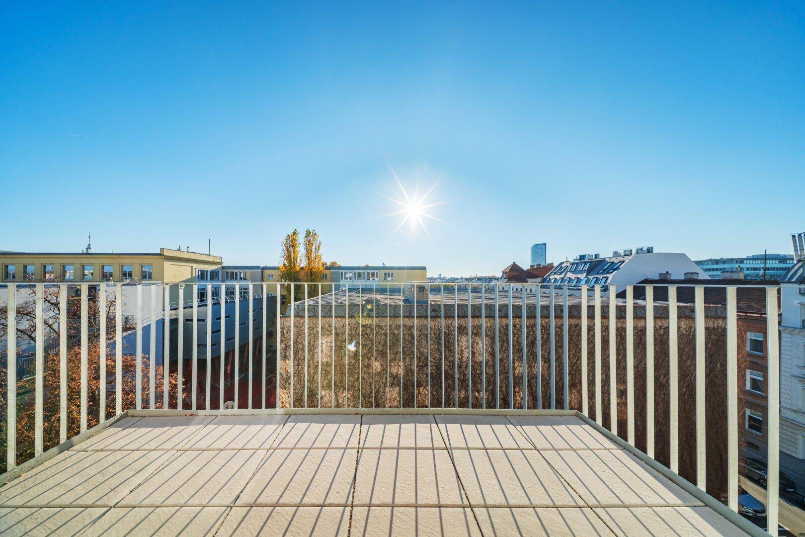 Sonniger Balkon mit weitem Blick über die Dächer der Stadt.