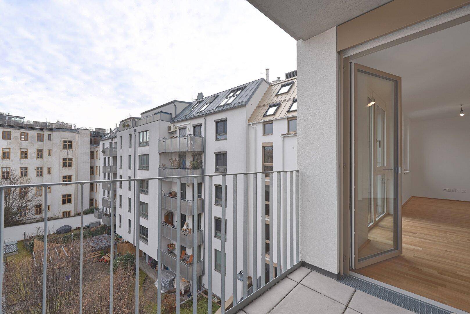 Balkon mit Blick auf den Innenhof und die umliegenden Wohngebäude, bietet eine ruhige Aussicht.