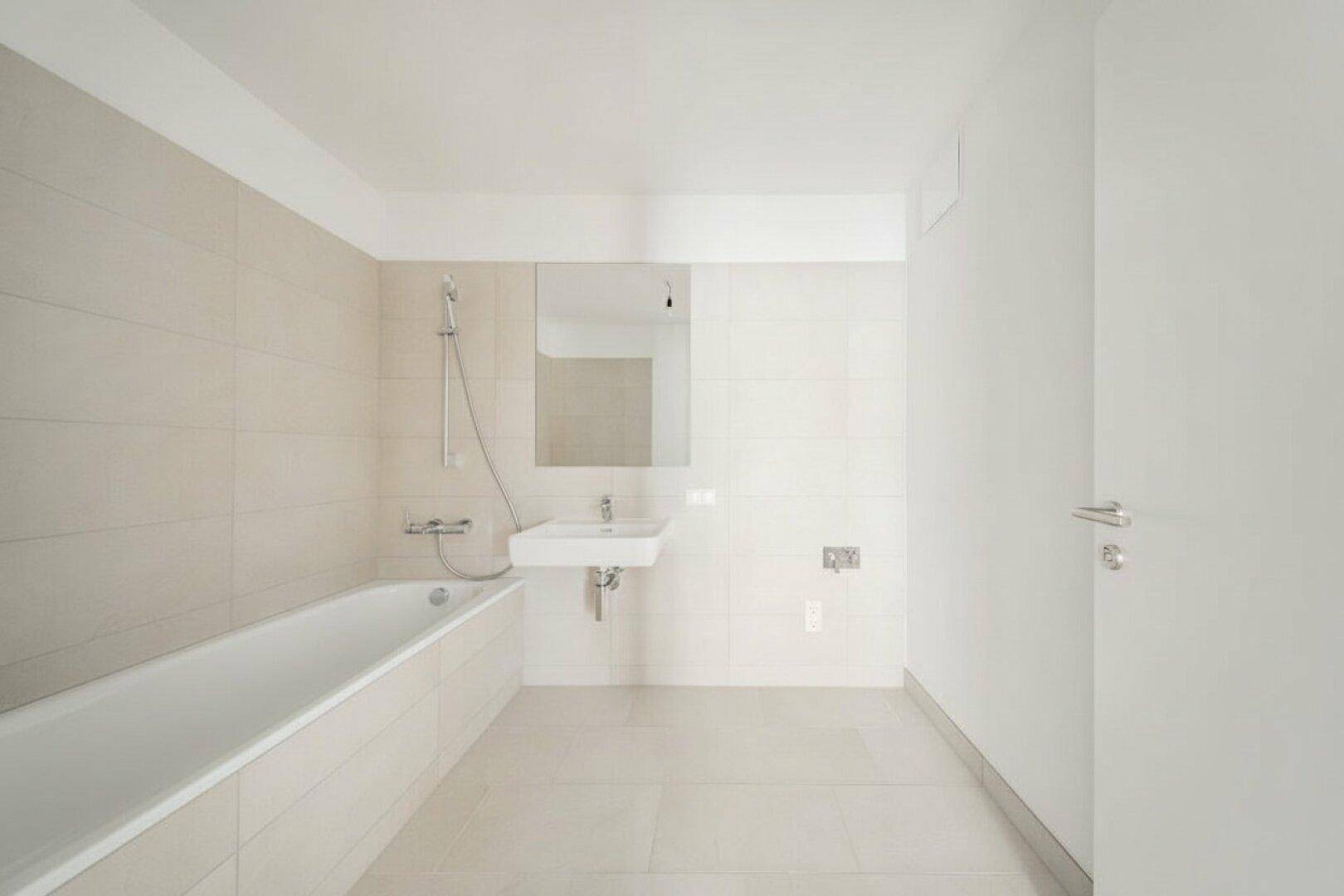 Helles Badezimmer mit Badewanne, modernem Waschbecken und großem Spiegel.