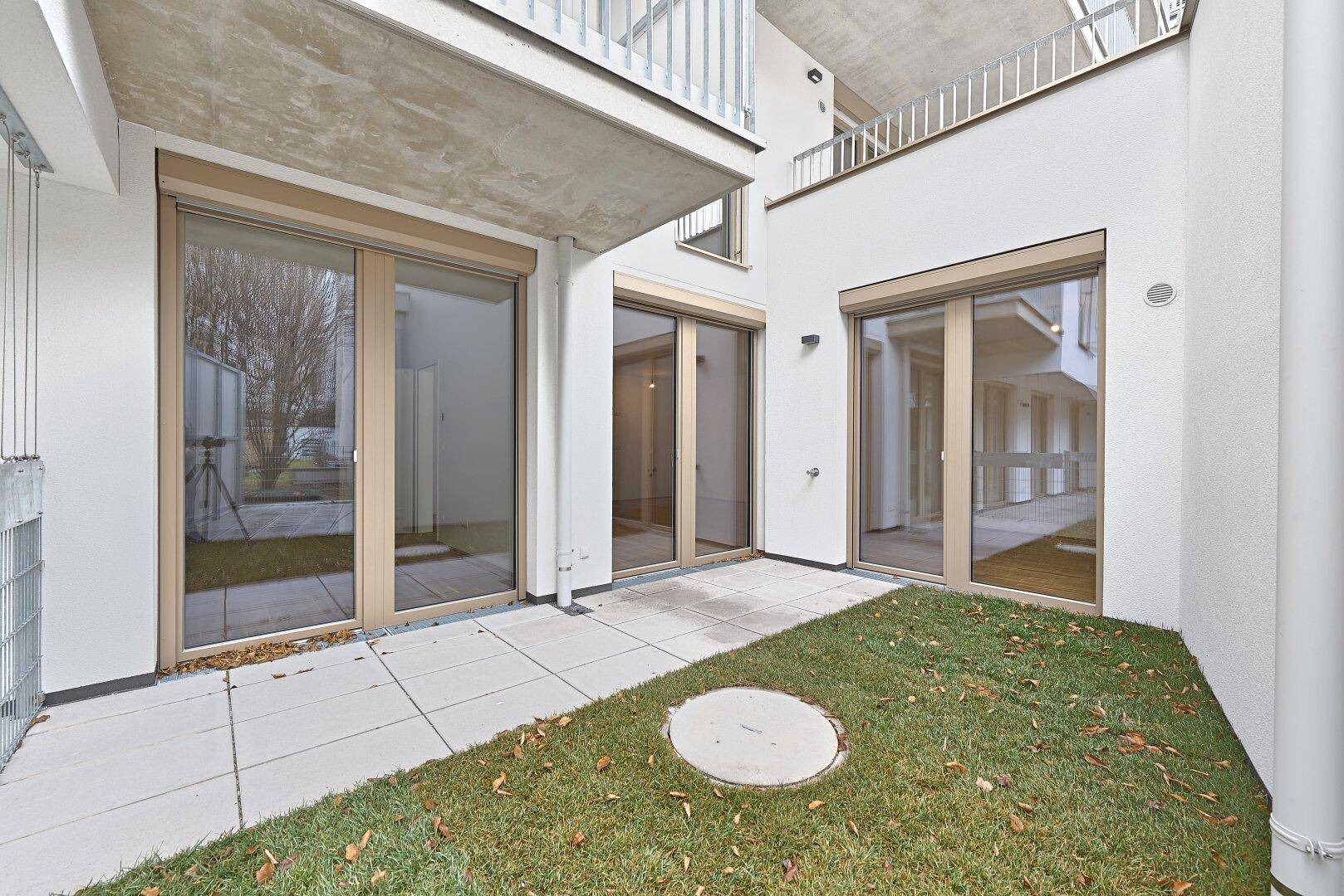 Private Terrasse mit Rasenfläche und Zugang zu den Innenräumen des Gebäudes.