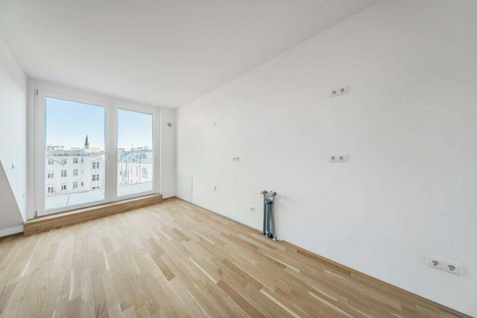 Heller Wohnraum mit großen Fenstern, Holzboden und Blick auf die Stadt.