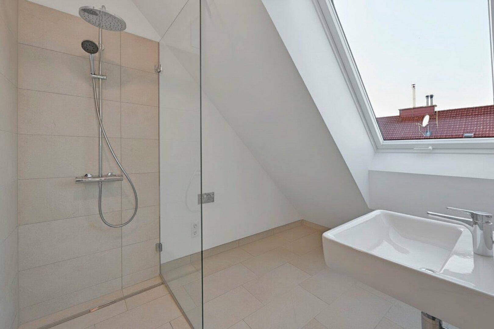 Modernes Badezimmer mit ebenerdiger Dusche, Waschbecken und Dachfenster mit Ausblick.
