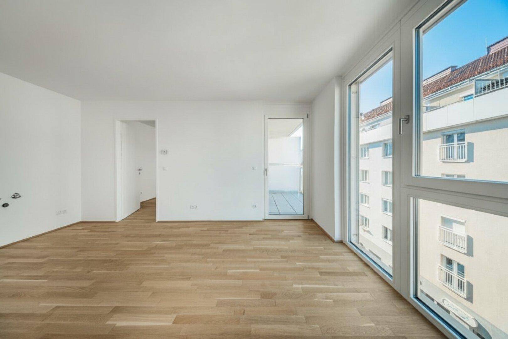 Geräumiger, heller Raum mit Parkettboden und großen Fenstern, die eine weite Aussicht bieten.