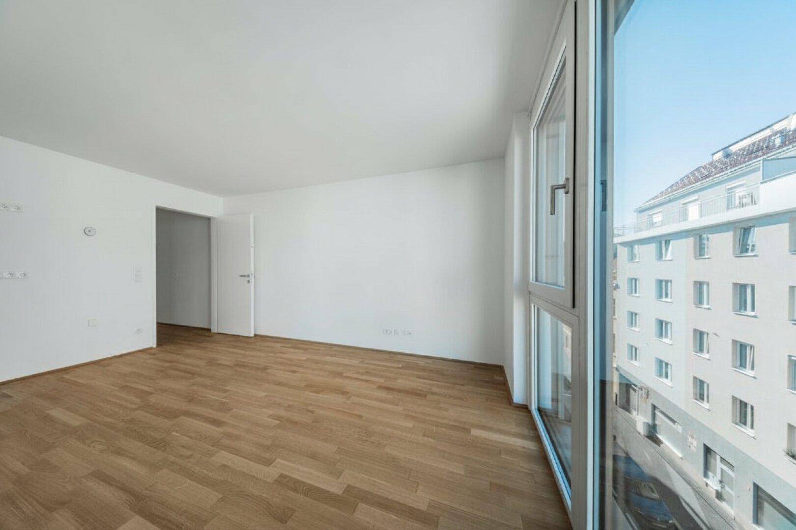Geräumiger, unmöblierter Raum mit viel Tageslicht durch große Fenster, bereit zur individuellen Gestaltung.