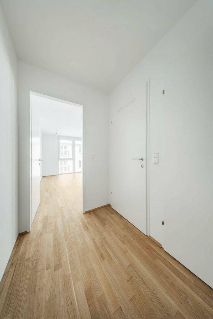 Geräumiger Eingangsbereich mit Holzboden, der zu den Wohnbereichen der Immobilie führt.