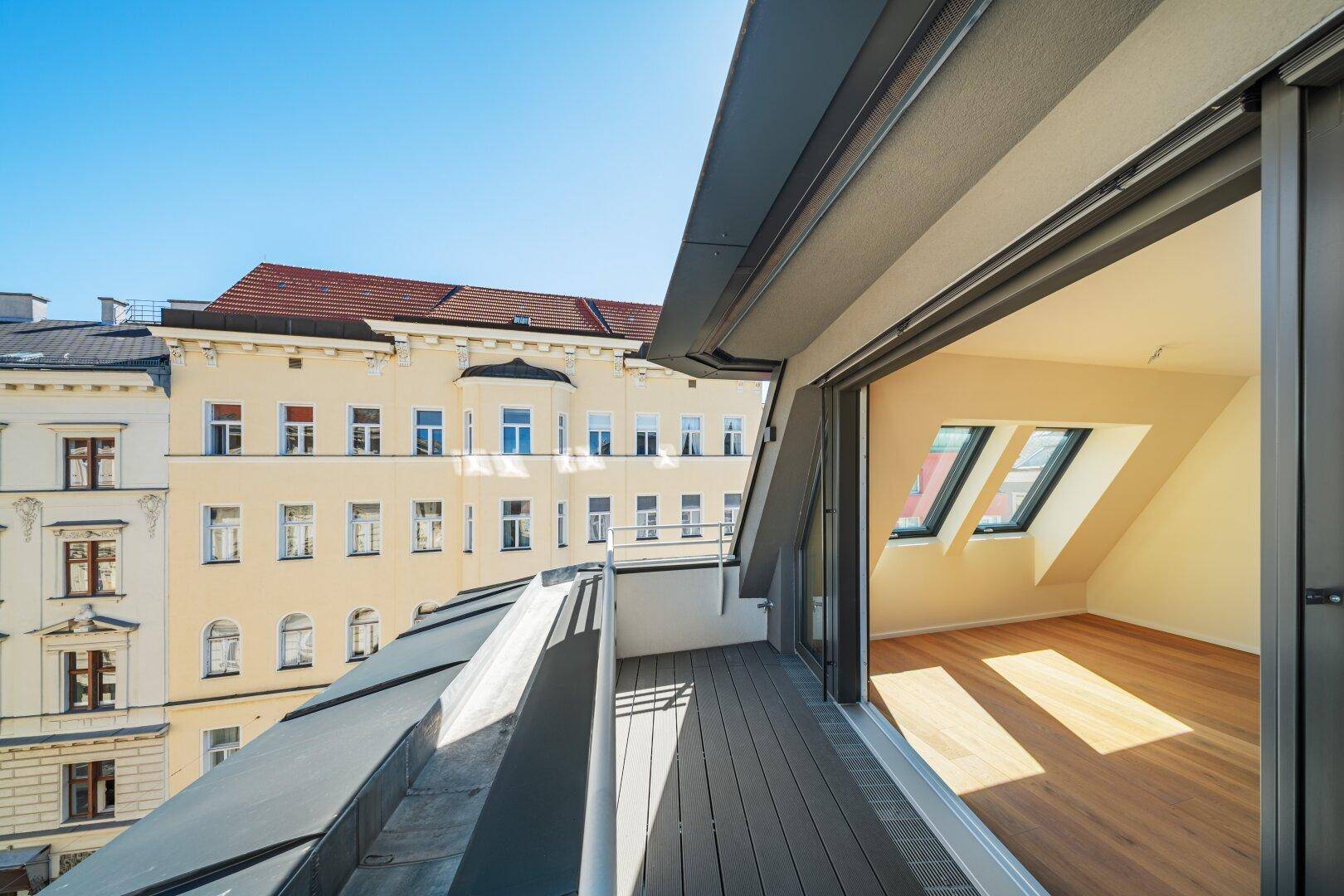 Geräumiger Innenraum mit Holzboden und Schiebetüren zum Balkon, bietet einen weiten Stadtblick.