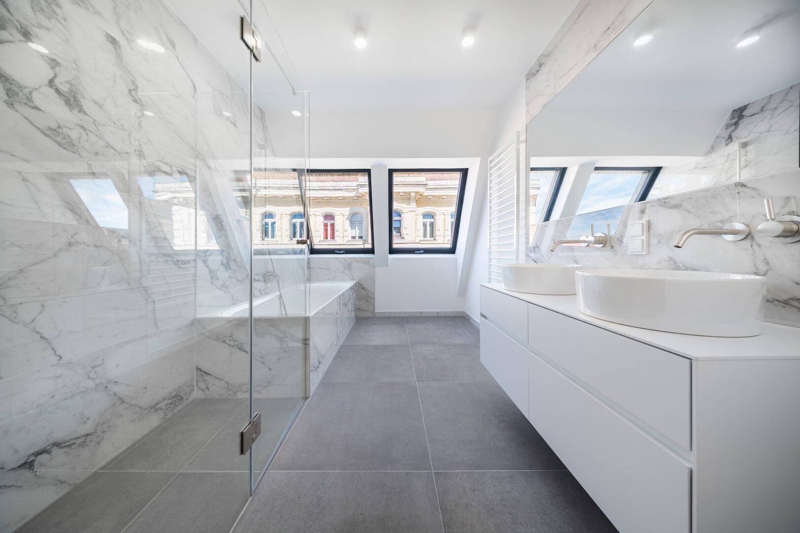 Modernes Badezimmer mit Marmorfliesen, Doppelwaschbecken und großer Dusche im Dachgeschoss.