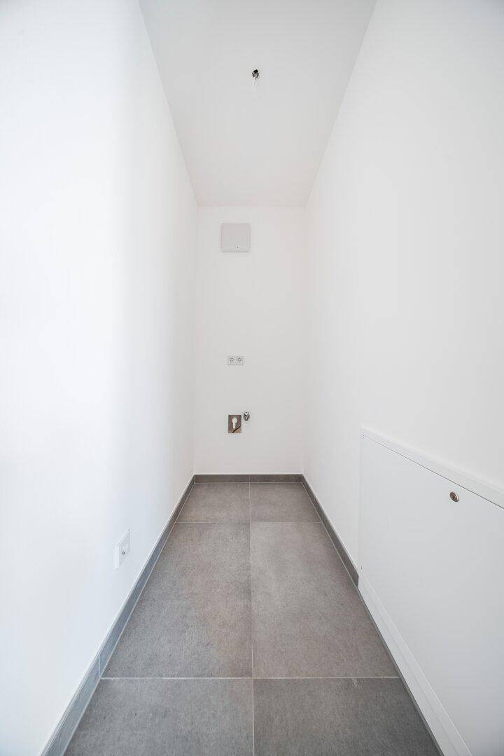 Praktischer Abstellraum mit Fliesenboden und weißen Wänden, ideal für Haushaltsgeräte.