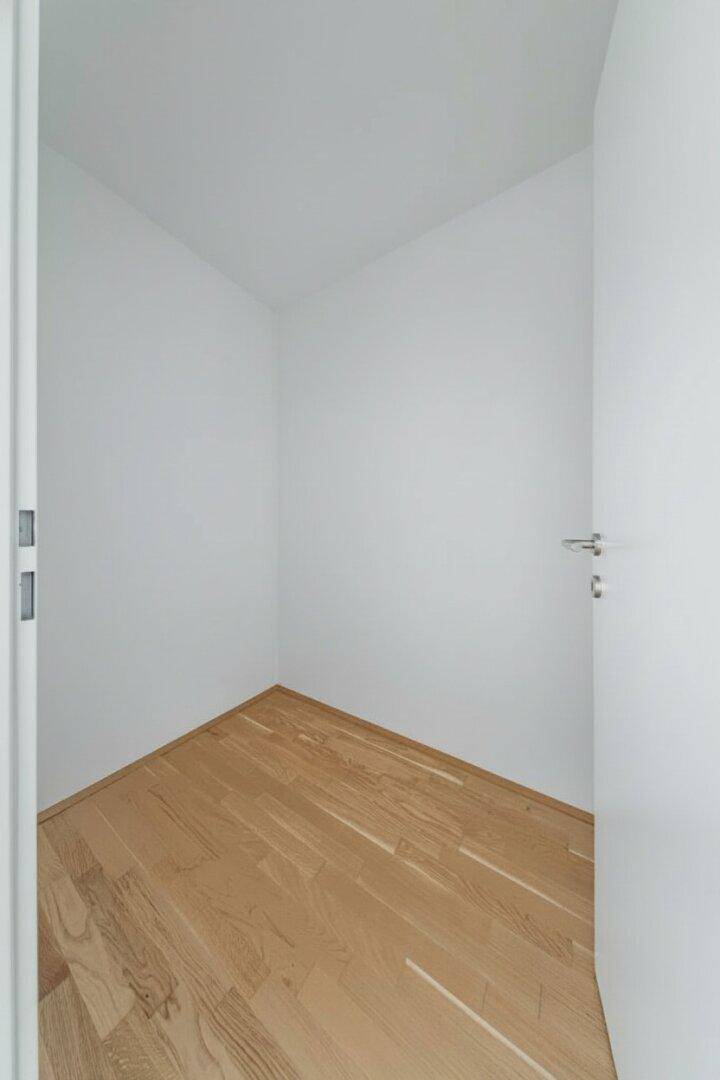 Kleiner, leerer Raum mit Holzboden und weißen Wänden, ideal als Abstellraum oder begehbarer Kleiderschrank.