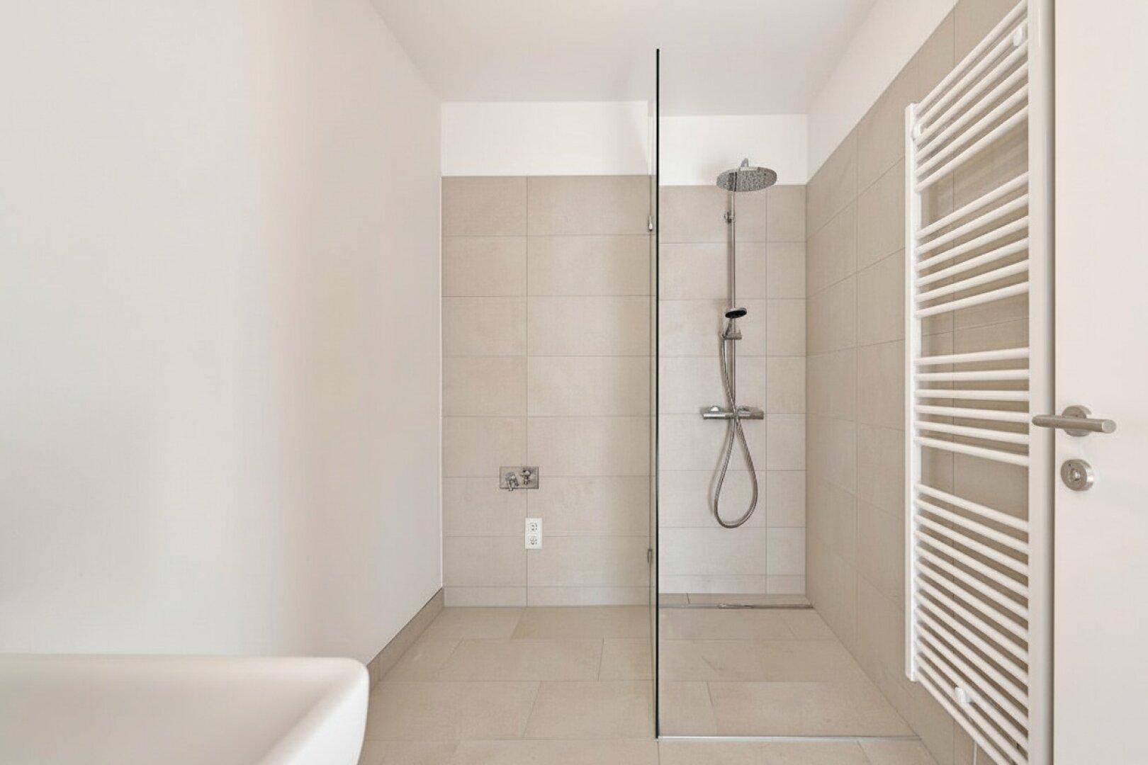 Modernes Badezimmer mit ebenerdiger Dusche und beheiztem Handtuchhalter, minimalistisches Design.