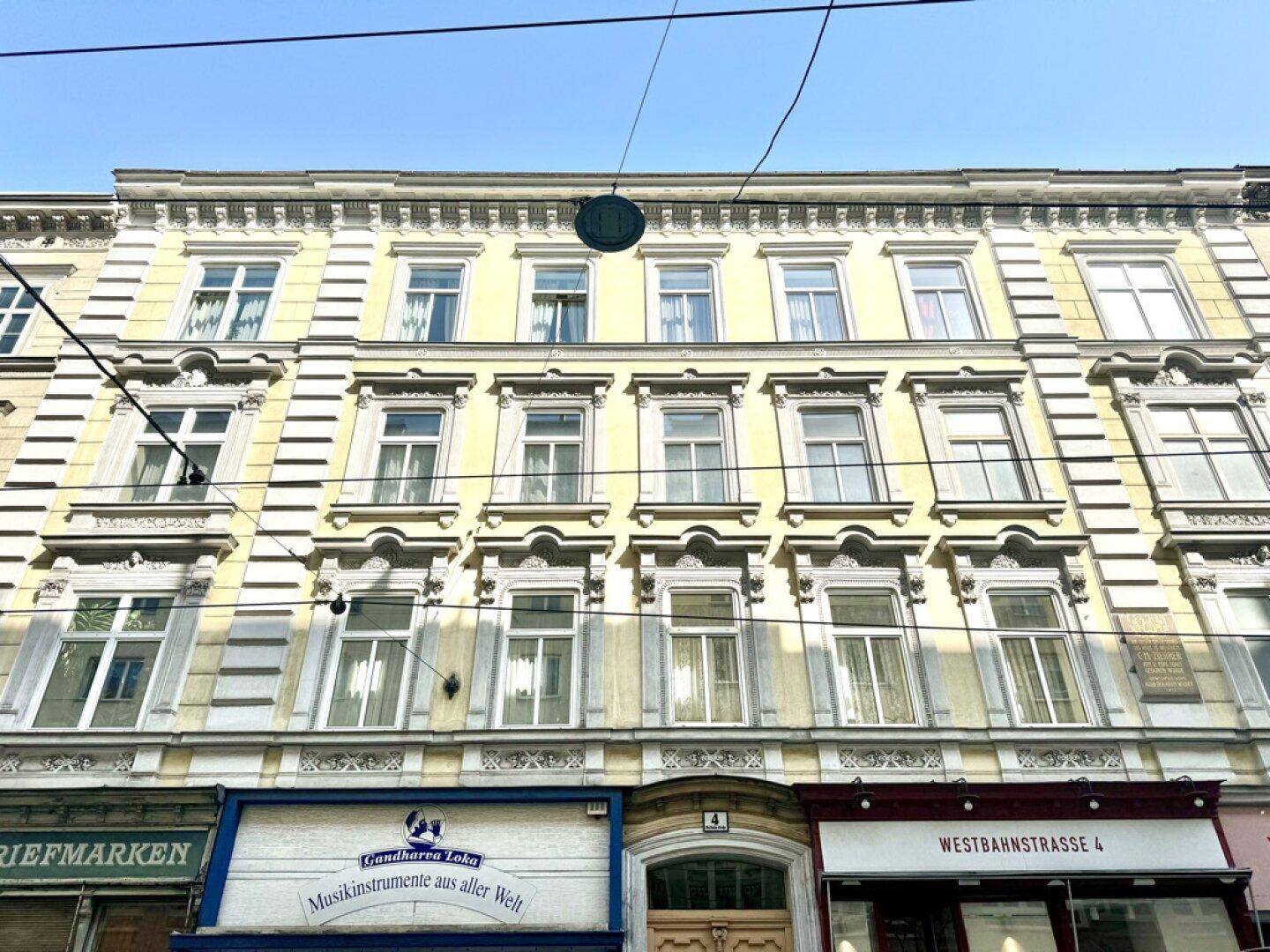 Historische Fassade eines Altbaus mit vielen Fenstern und dekorativen Elementen im Stadtzentrum.