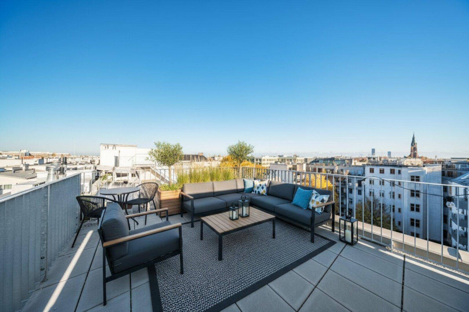 Stilvolle Dachterrasse mit modernen Lounge-Möbeln und weitem Blick über die Stadt.