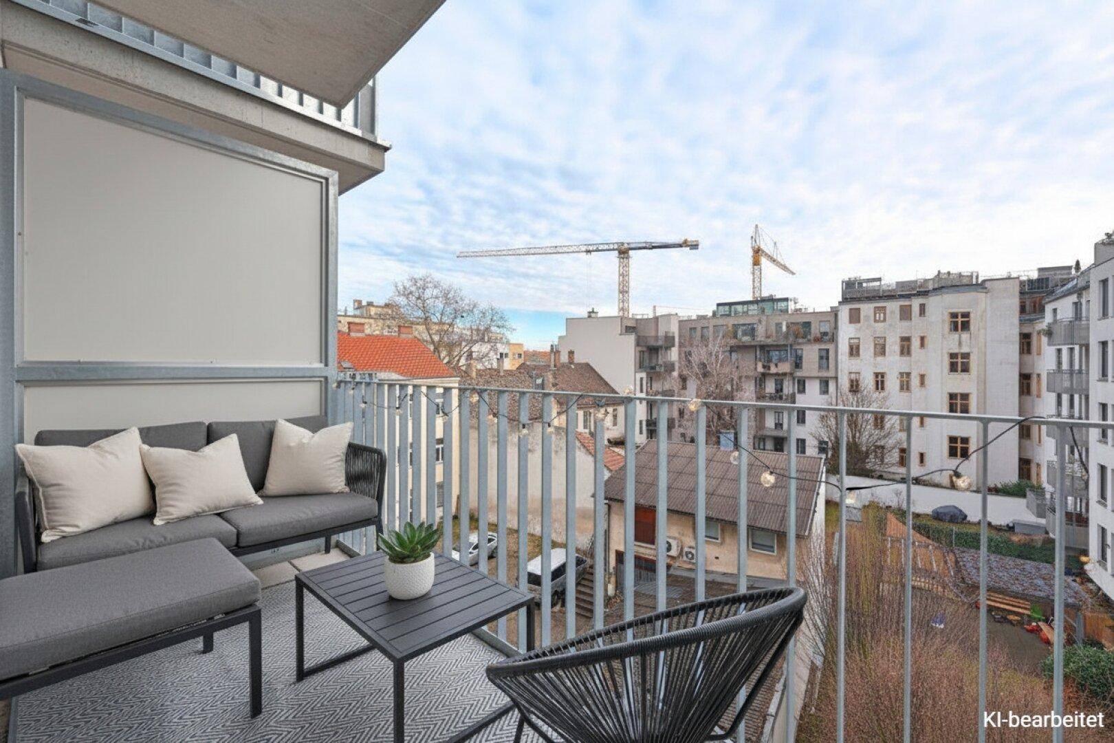 Möblierter Balkon mit Sitzgelegenheiten und Blick auf die Stadt, ideal zum Entspannen.