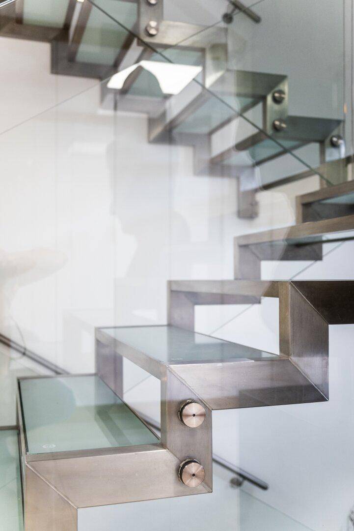 Detailansicht der modernen Treppe mit Glas und Metallkonstruktion.