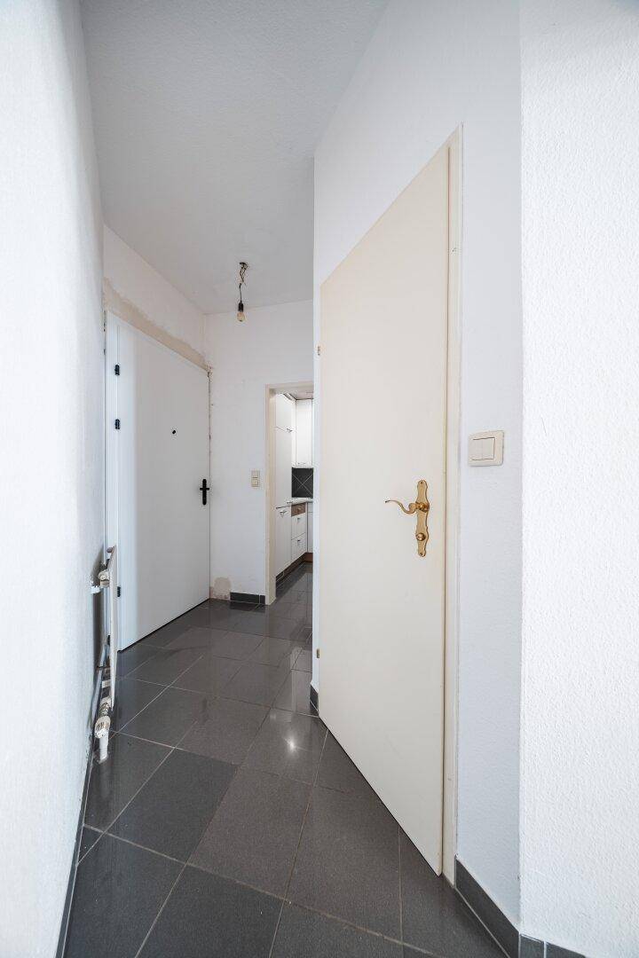 Heller Flur mit Fliesenboden und Zugang zu verschiedenen Räumen der Wohnung.
