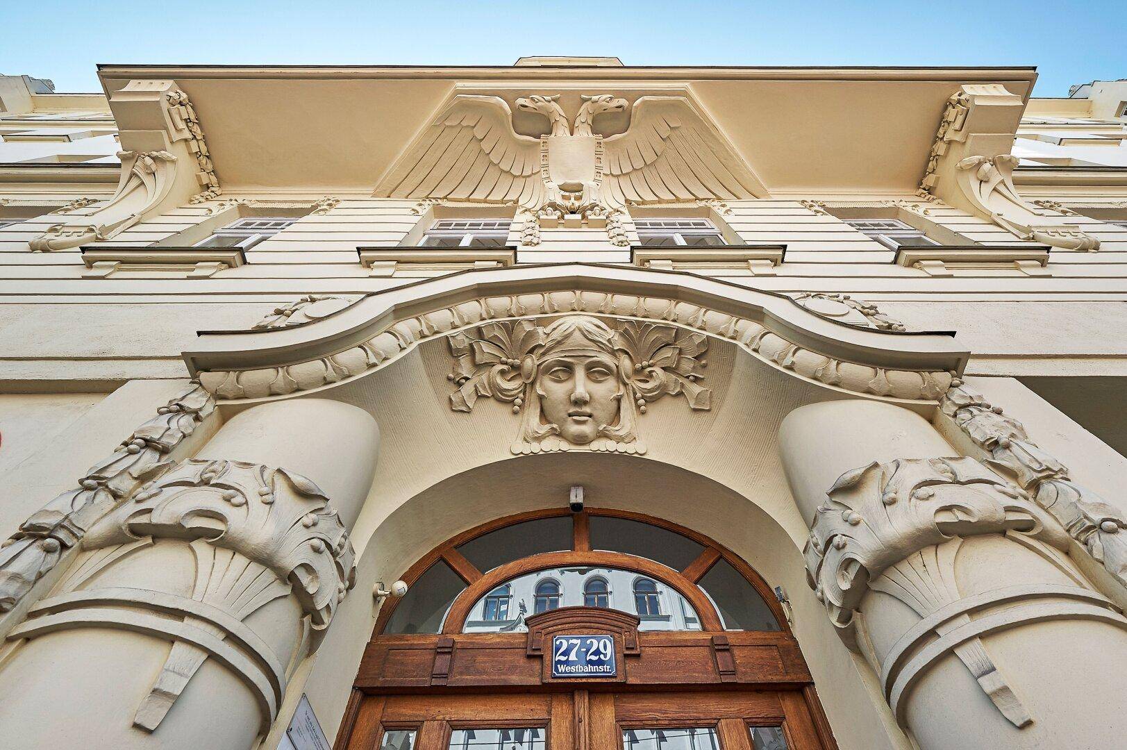Detailaufnahme der kunstvollen Fassade eines historischen Gebäudes mit Skulpturen und reichen Verzierungen.