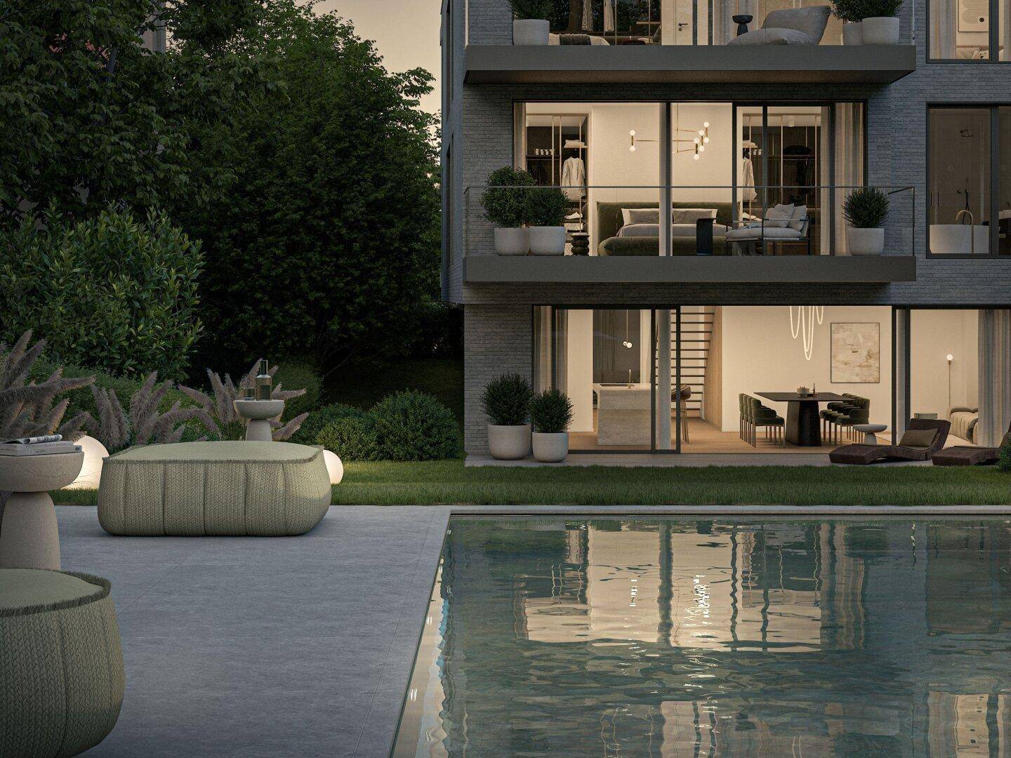 Außenansicht des Gebäudes mit Poolbereich und Garten am Abend.