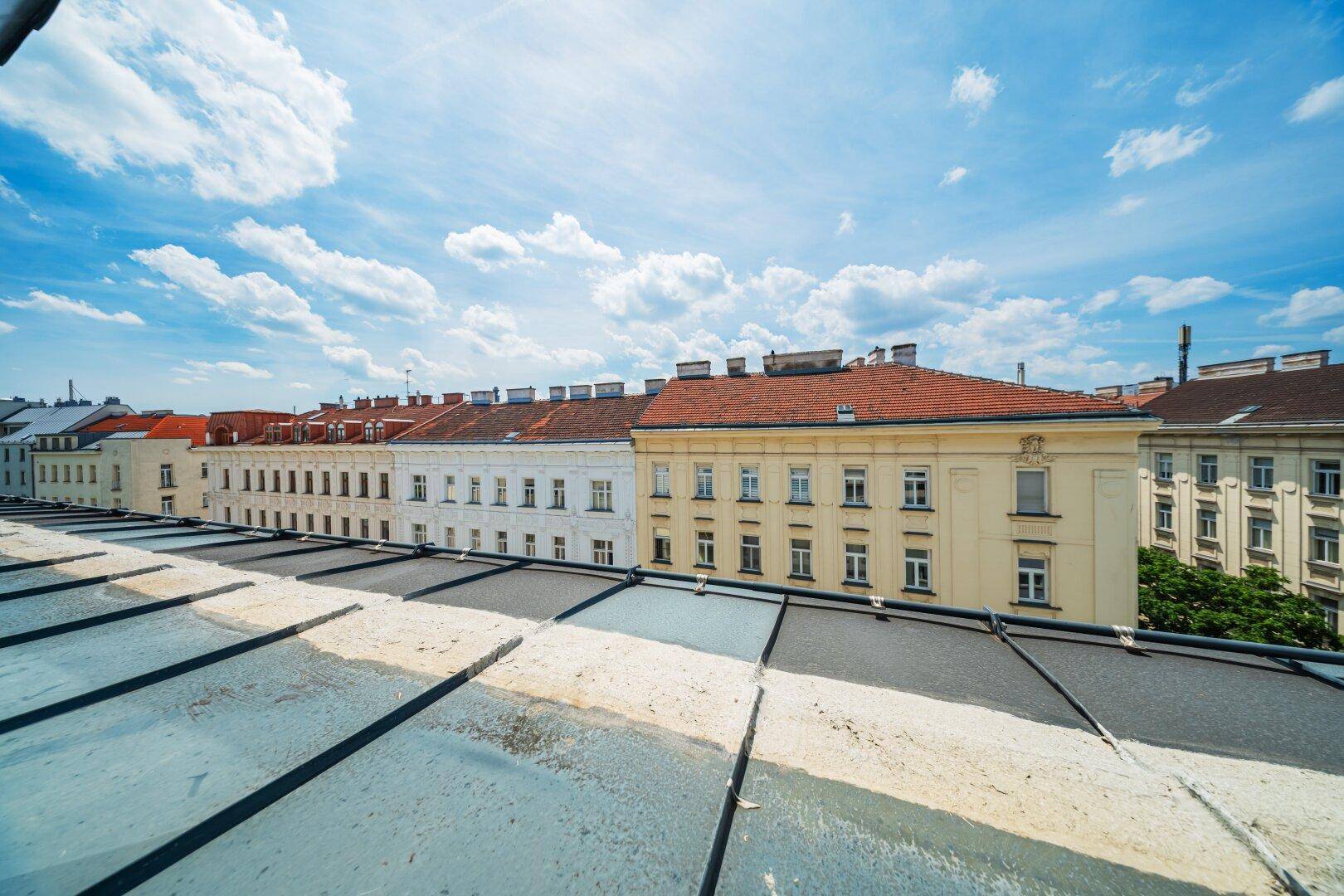 Panoramablick über die Dächer der Stadt mit historischer Architektur unter blauem Himmel.