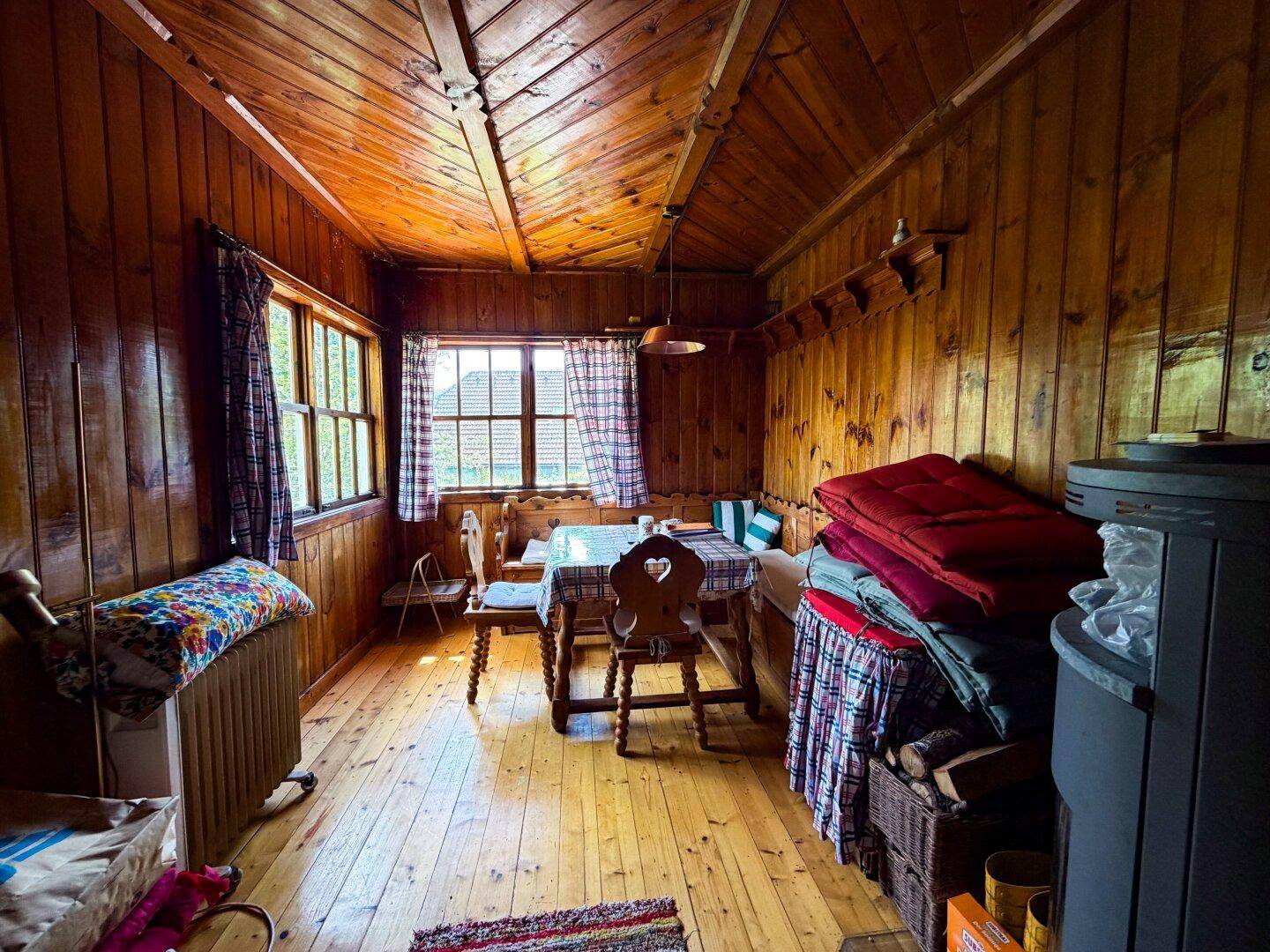 Gemütlicher Essbereich im alpinen Stil mit Holztäfelung, Holzboden und traditionellen Möbeln.