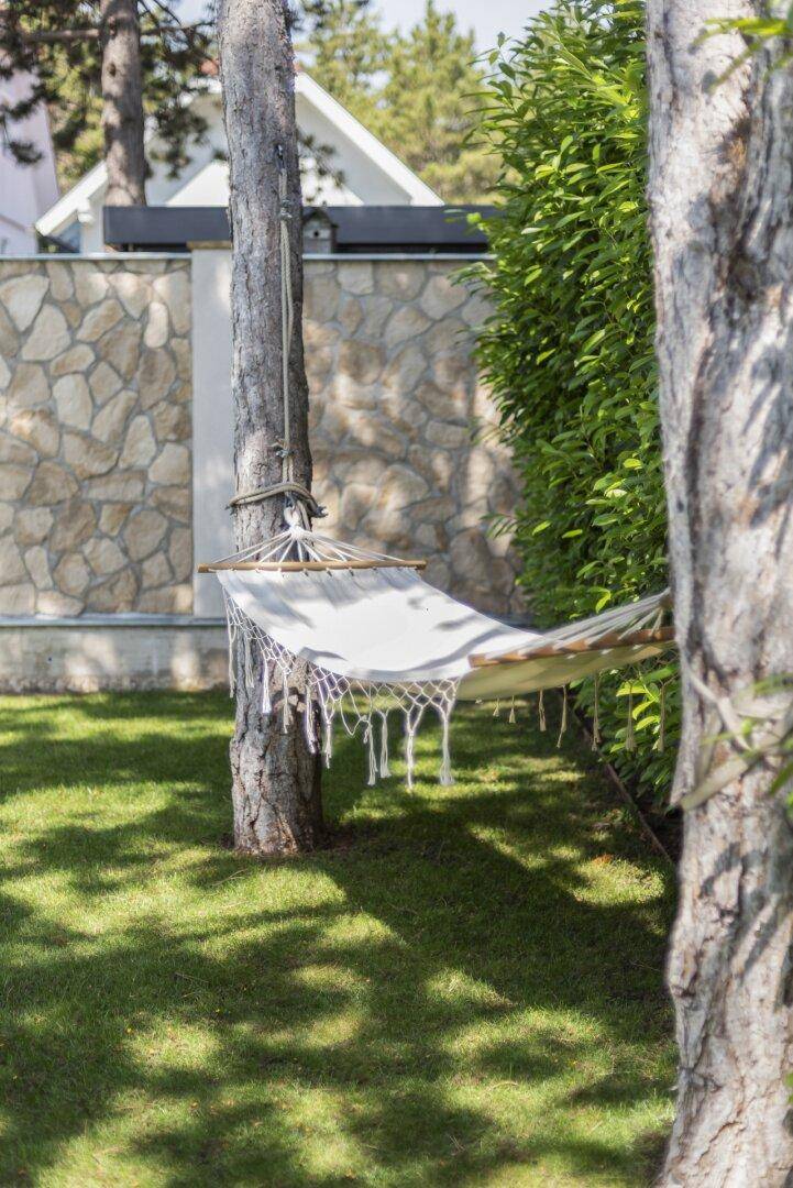 Gemütliche Hängematte zwischen Bäumen im grünen Garten, ideal zum Entspannen.