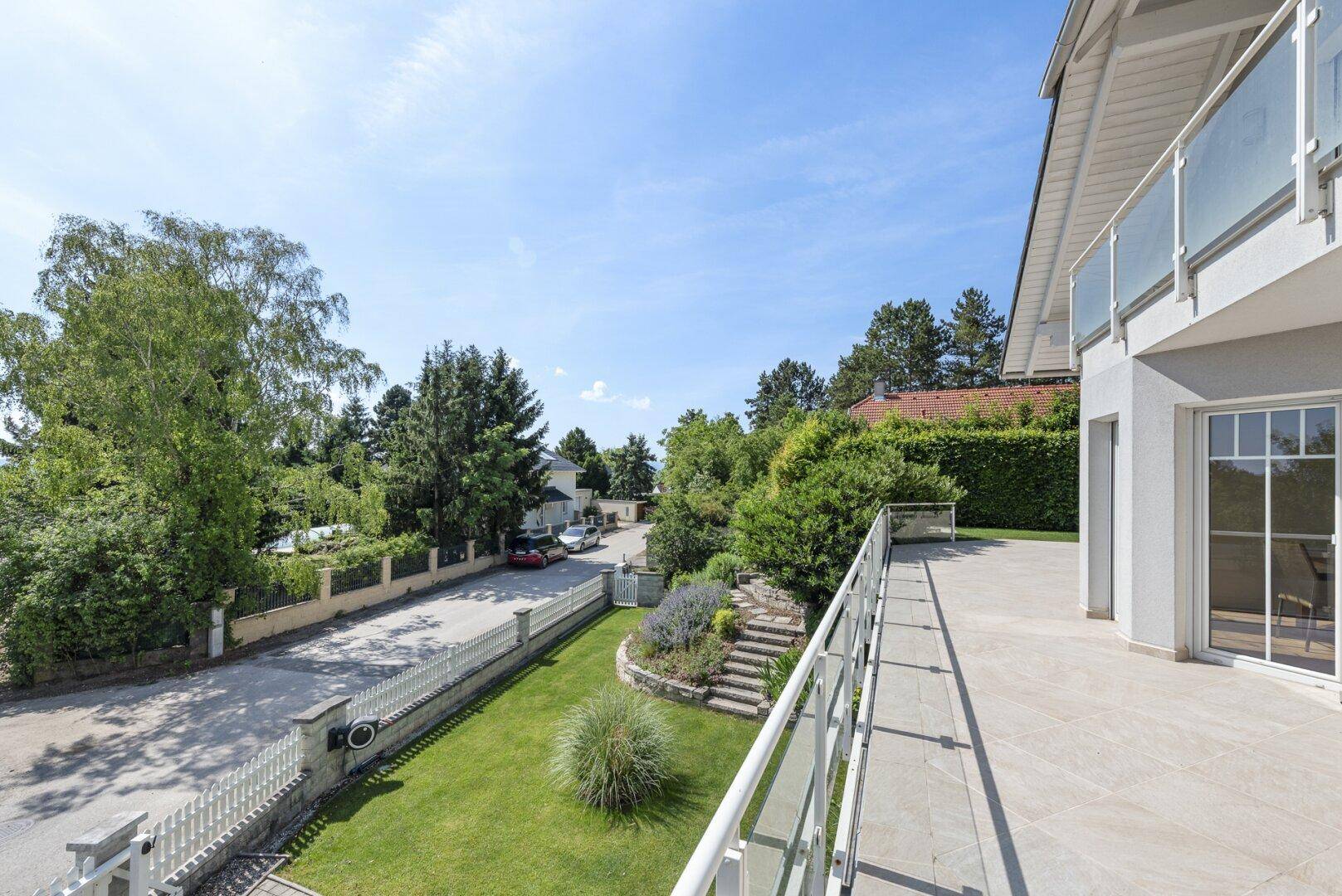 Große Terrasse mit Blick auf die ruhige Wohnstraße und die grüne Umgebung.