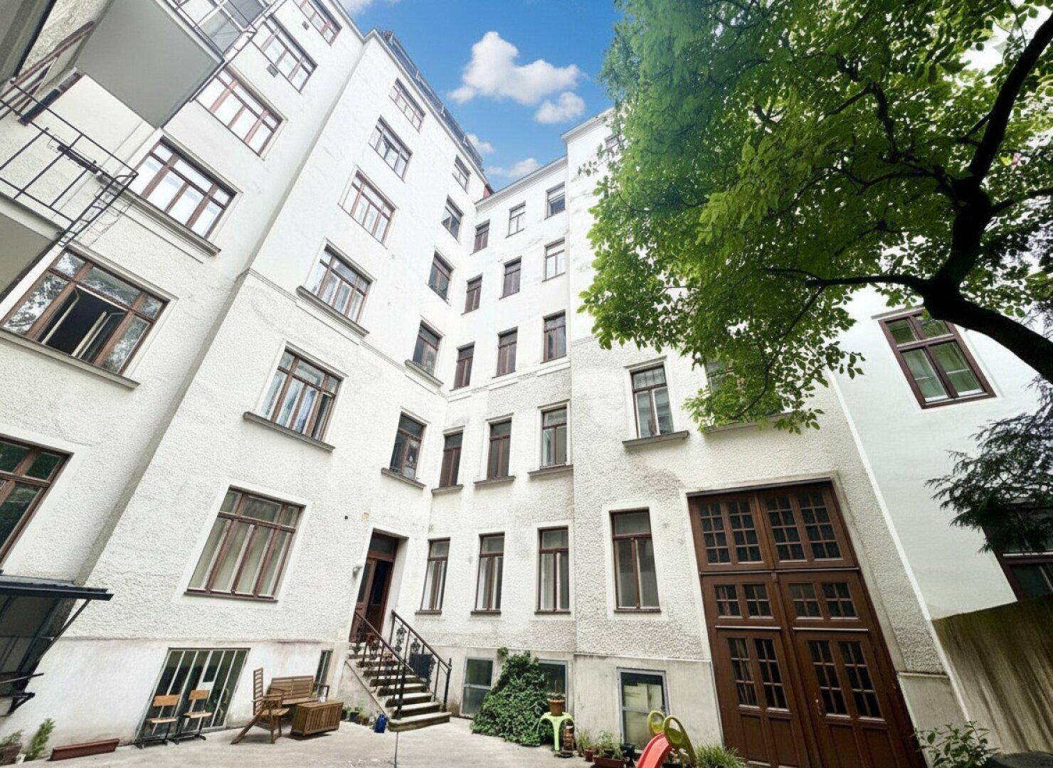 Innenhof eines Wohngebäudes mit Fahrradabstellplatz und Kinderspielgeräten.