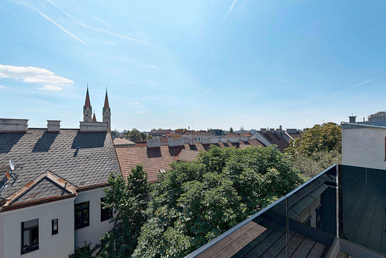 Dachterrasse mit Panoramablick über die Dächer der Stadt und Kirchtürme.