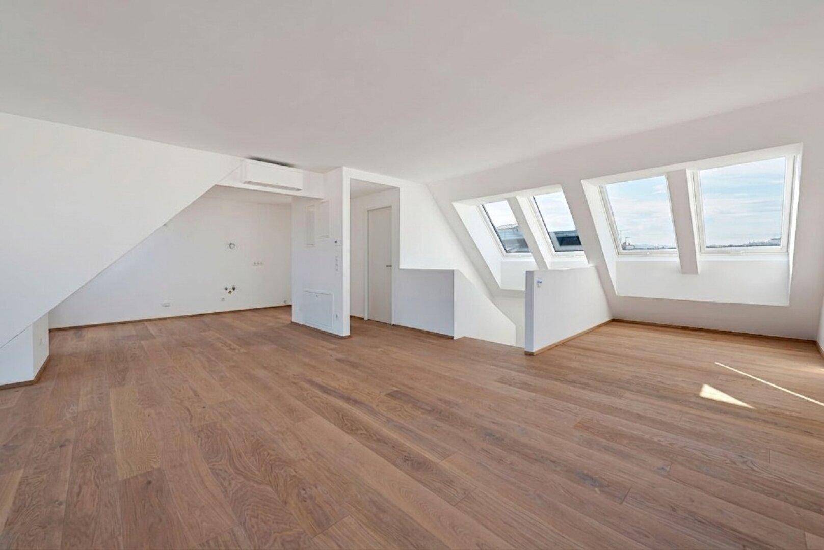 Heller Wohnbereich mit Holzboden, Dachfenstern und Klimaanlage.