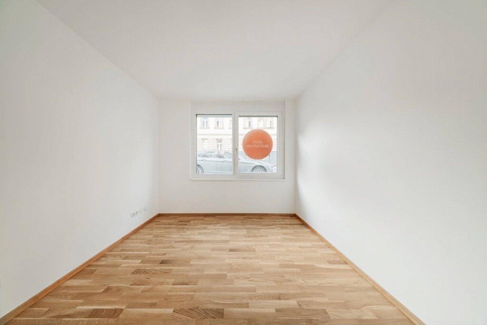 Kleiner, heller Raum mit Parkettboden und einem Fenster, ideal als Schlafzimmer oder Arbeitszimmer.