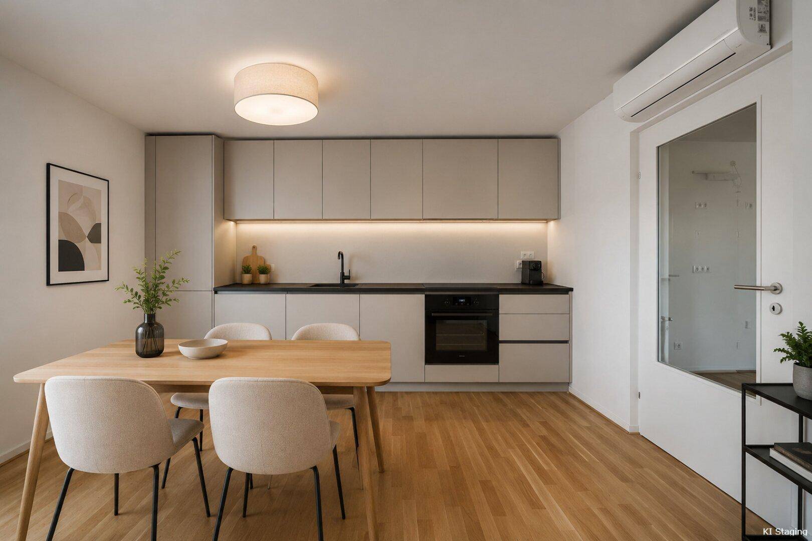 Moderne Küche mit Essbereich, hellgrauen Schränken, Holzboden und Klimaanlage.