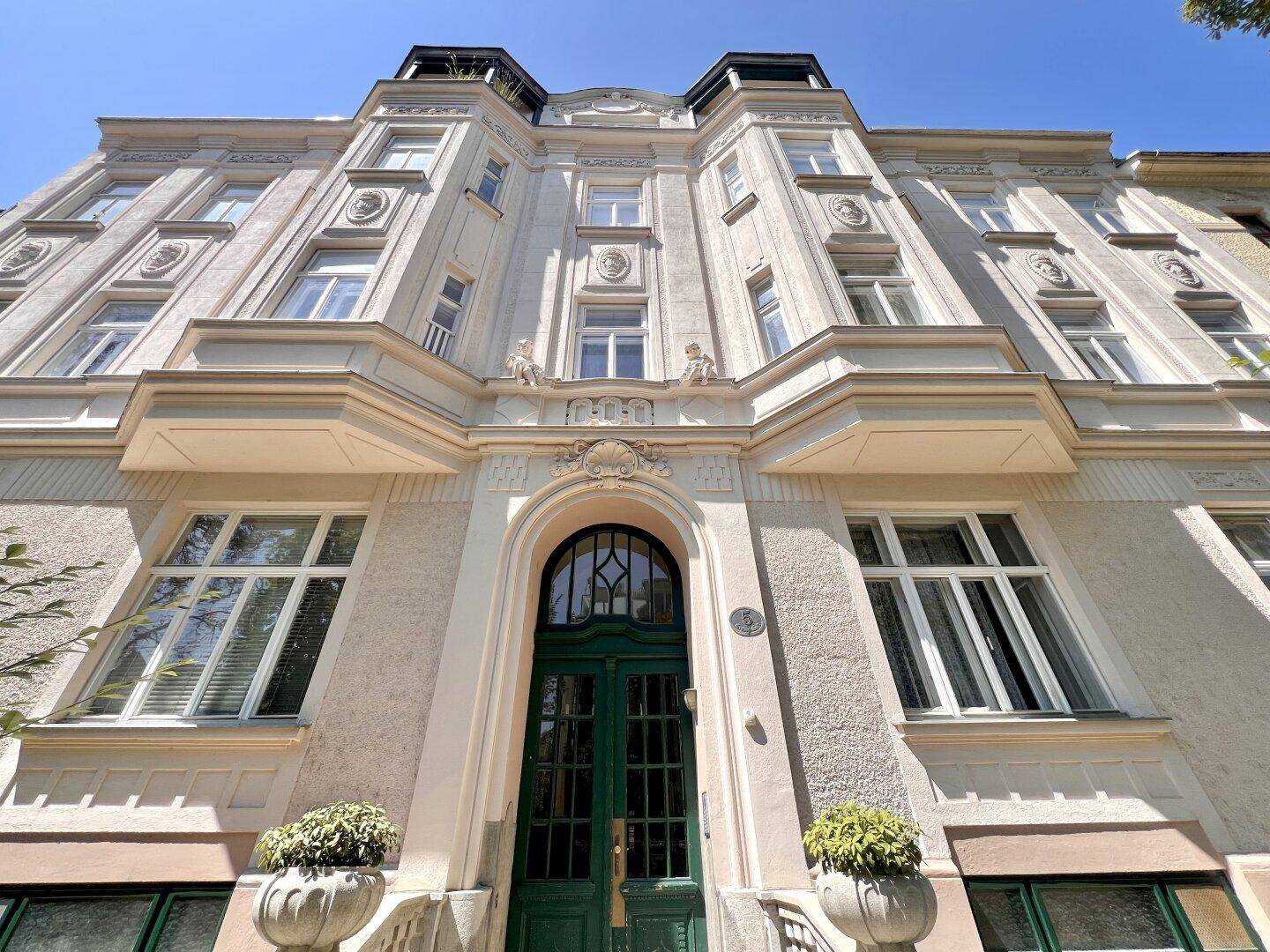 Prachtvolle Altbaufassade mit aufwendigen Stuckelementen und einem einladenden Eingangsbereich.