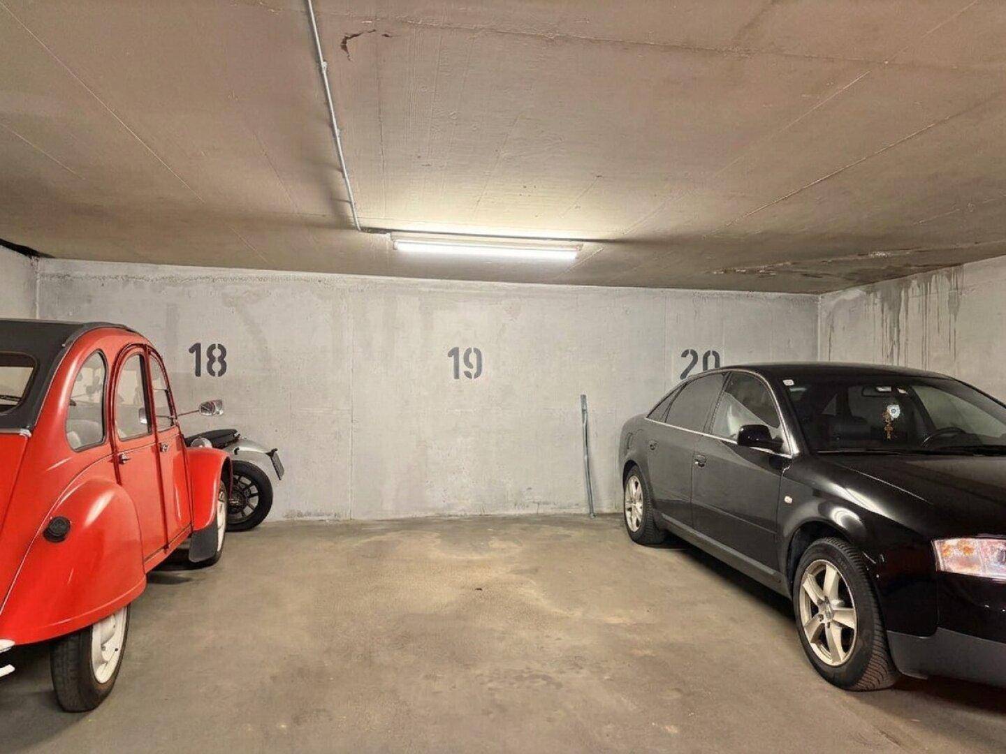 Tiefgarage mit zwei Stellplätzen und Betonwänden, gut beleuchtet.