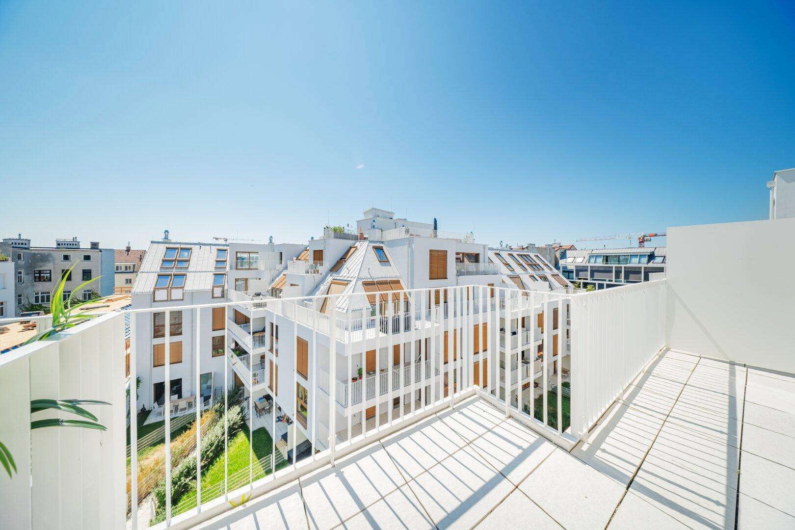 Weitläufige Dachterrasse mit Panoramablick über die Stadt und grüne Innenhöfe.