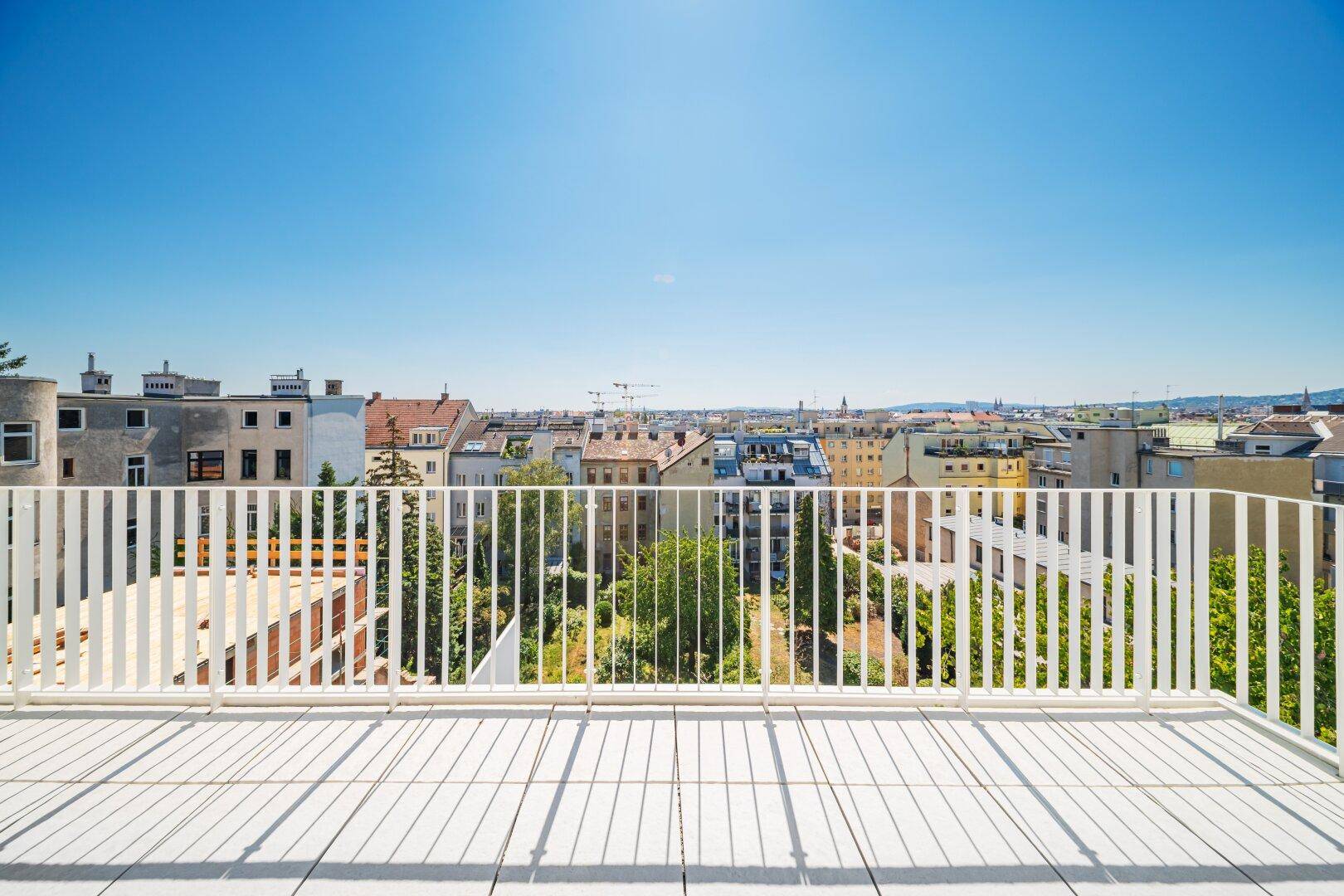 Panoramablick von der Dachterrasse über die Dächer der Stadt an einem sonnigen Tag.