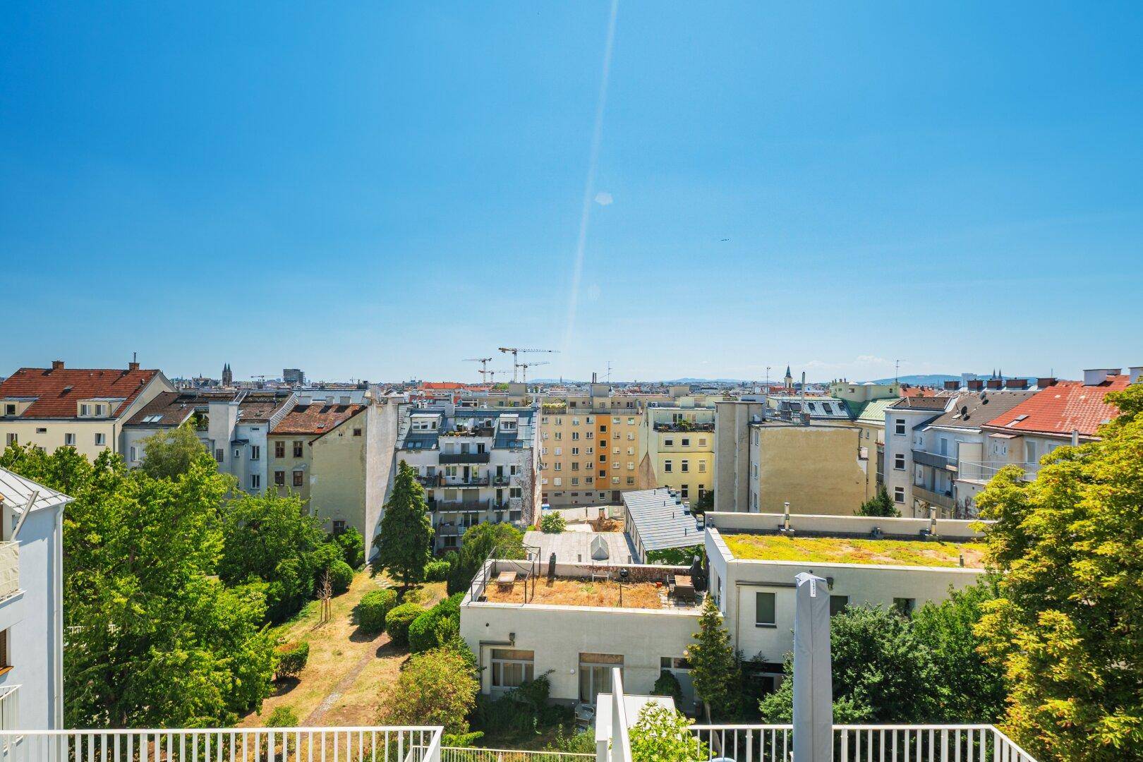 Weiter Blick über die Stadt mit einer Mischung aus modernen und älteren Gebäuden und Grünflächen.