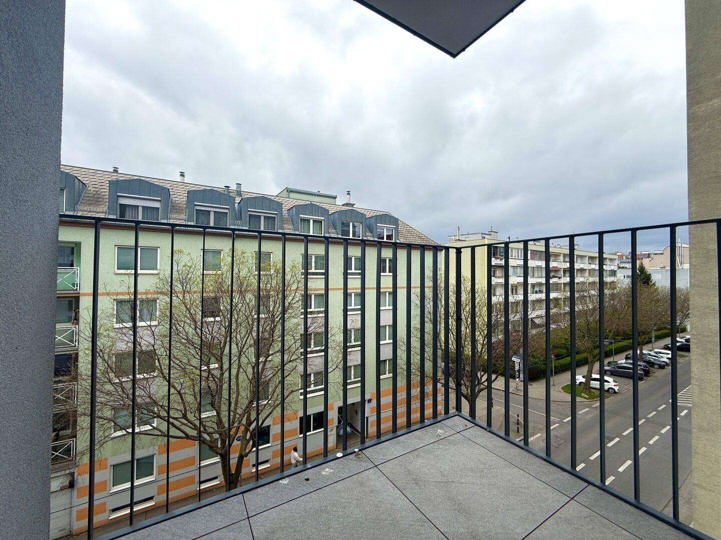 Balkon mit Blick auf die umliegenden Gebäude und die Straße, ideal für entspannte Stunden.