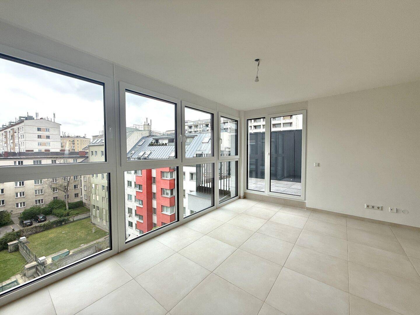 Heller Wohnraum mit großen Fenstern, die einen weiten Blick über die Stadt bieten.