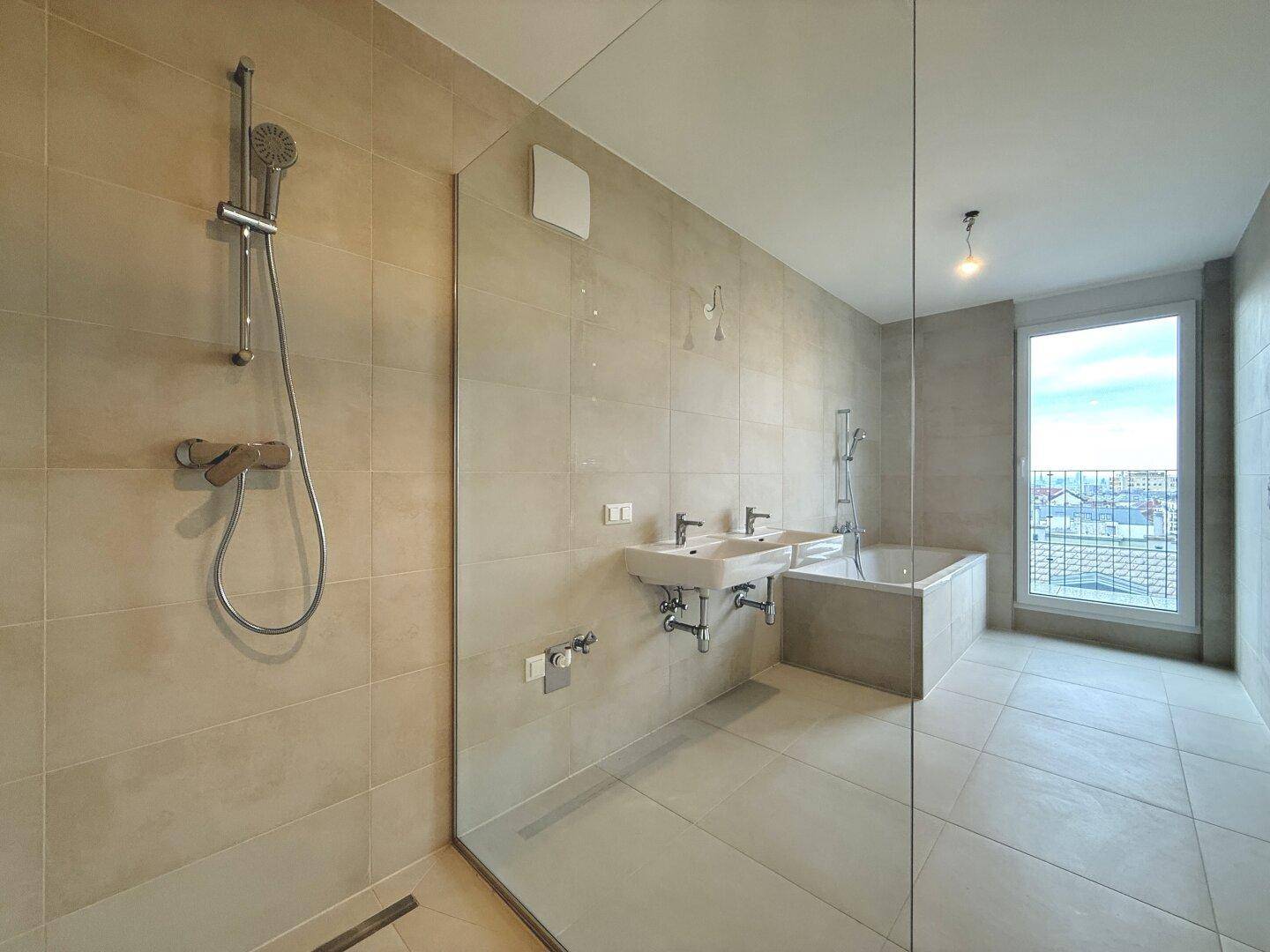 Modernes Badezimmer mit begehbarer Dusche, Badewanne, Doppelwaschbecken und Fenster.