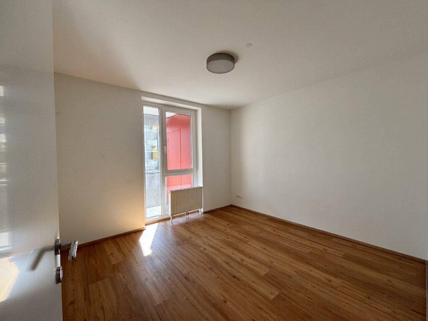 Geräumiges Zimmer mit Holzboden und Fenster, ideal als Schlaf- oder Arbeitszimmer.