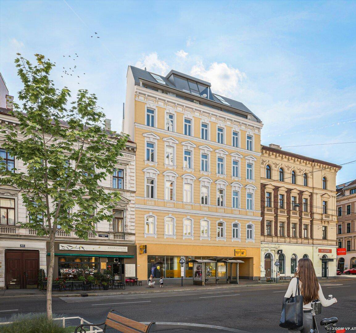 Straßenansicht des Gebäudes mit historischer Fassade und modernem Dachgeschossausbau.