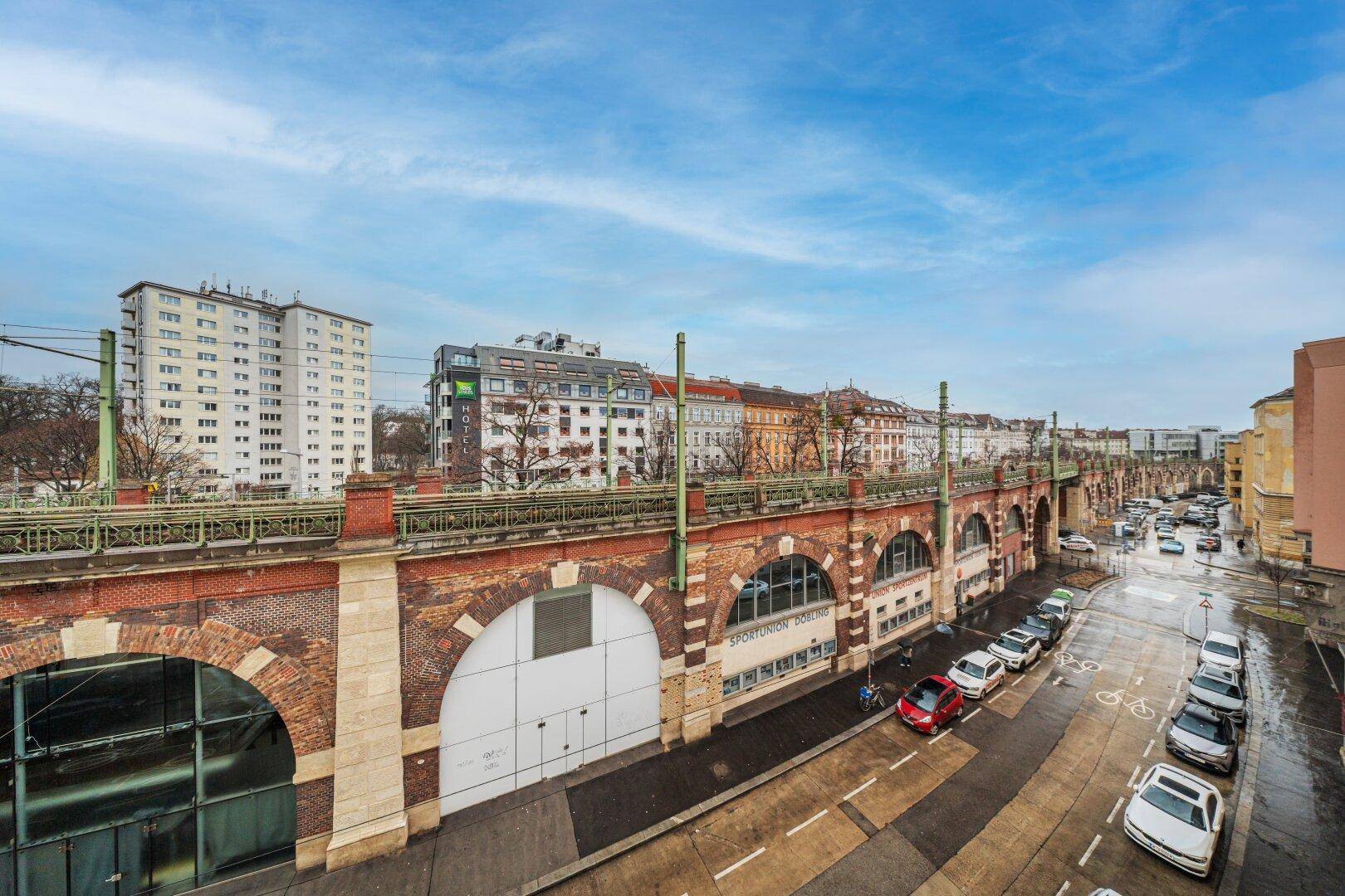 Panoramablick über die Stadt mit einer markanten Brückenkonstruktion und urbaner Bebauung.