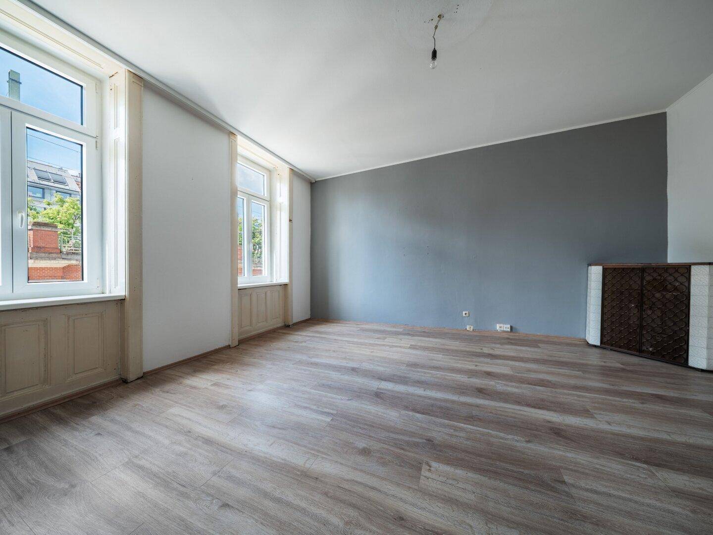 Geräumiges Zimmer mit Laminatboden und mehreren Fenstern, die viel Licht spenden.