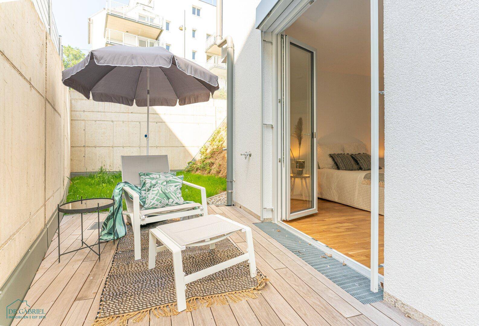 Gemütliche Terrasse mit Holzdeck, Sitzgelegenheiten und direktem Zugang zum Schlafzimmer.