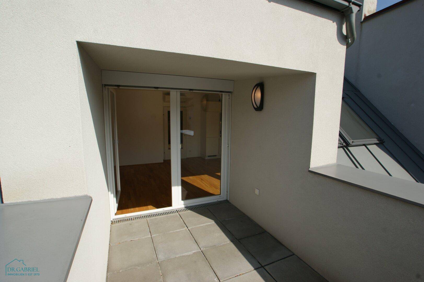 Kleiner Balkon mit Fliesenboden und Rollladen, zugänglich vom Innenbereich.