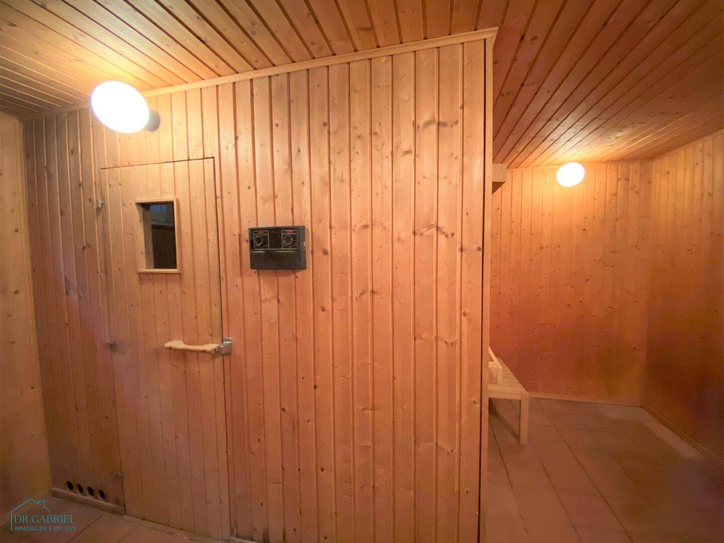 Traditionelle Holzsauna mit Bänken und Heizofen, ideal zur Entspannung.